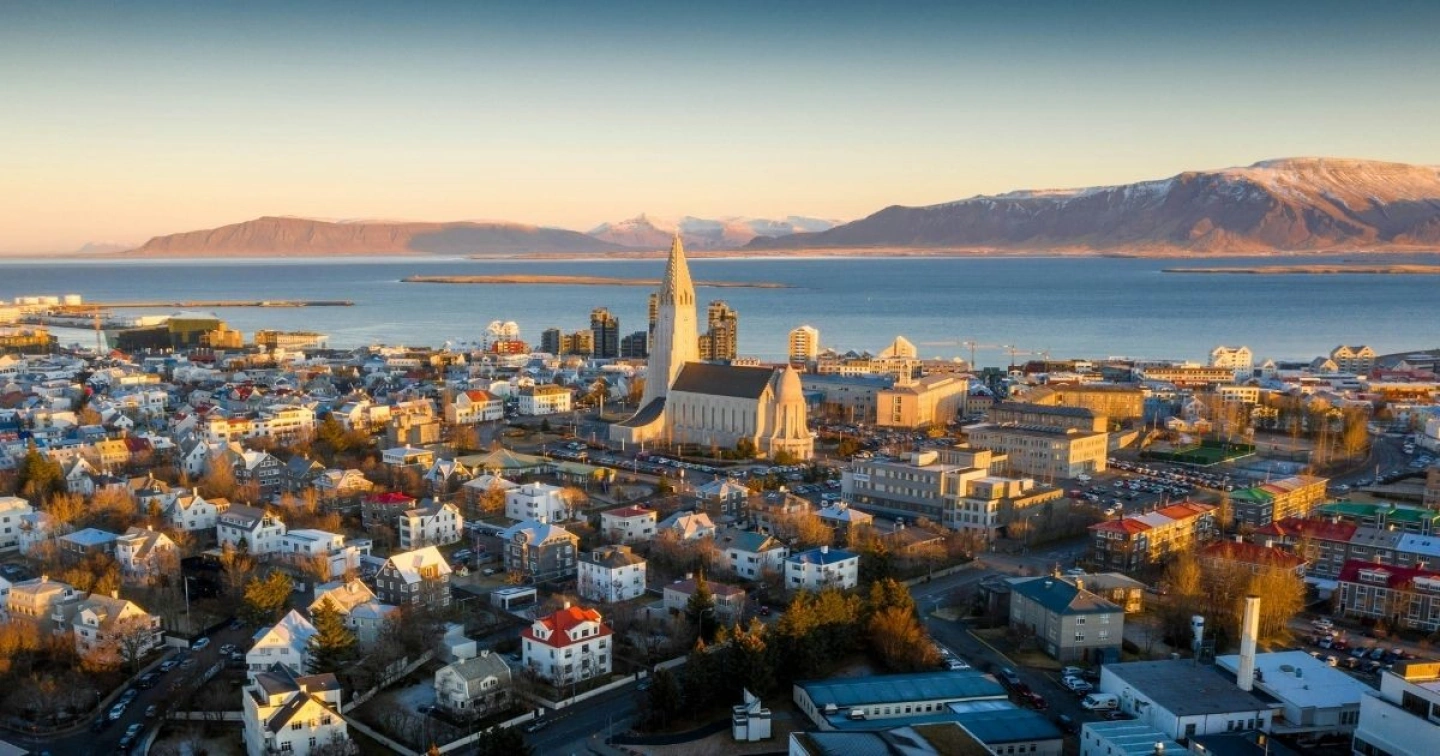 Luftaufnahme der Isländischen Hauptstadt Reykjavík inklusive Hallgrímskirkja und Meer im Hintergrund.